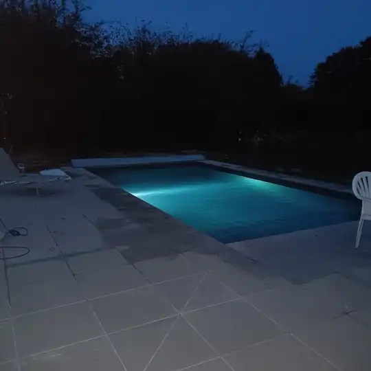 La piscine éclairée à la tombée de la nuit